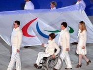 Паралимпийцы несут флаг.