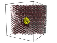 Пример расчетной ячейки: кристаллическая решетка диоксида урана (серые атомы — уран, красные — кислород), содержащая пузырь ксенона (желтые атомы). Черным цветом показаны атомы урана, вытесненные в междоузельные положения